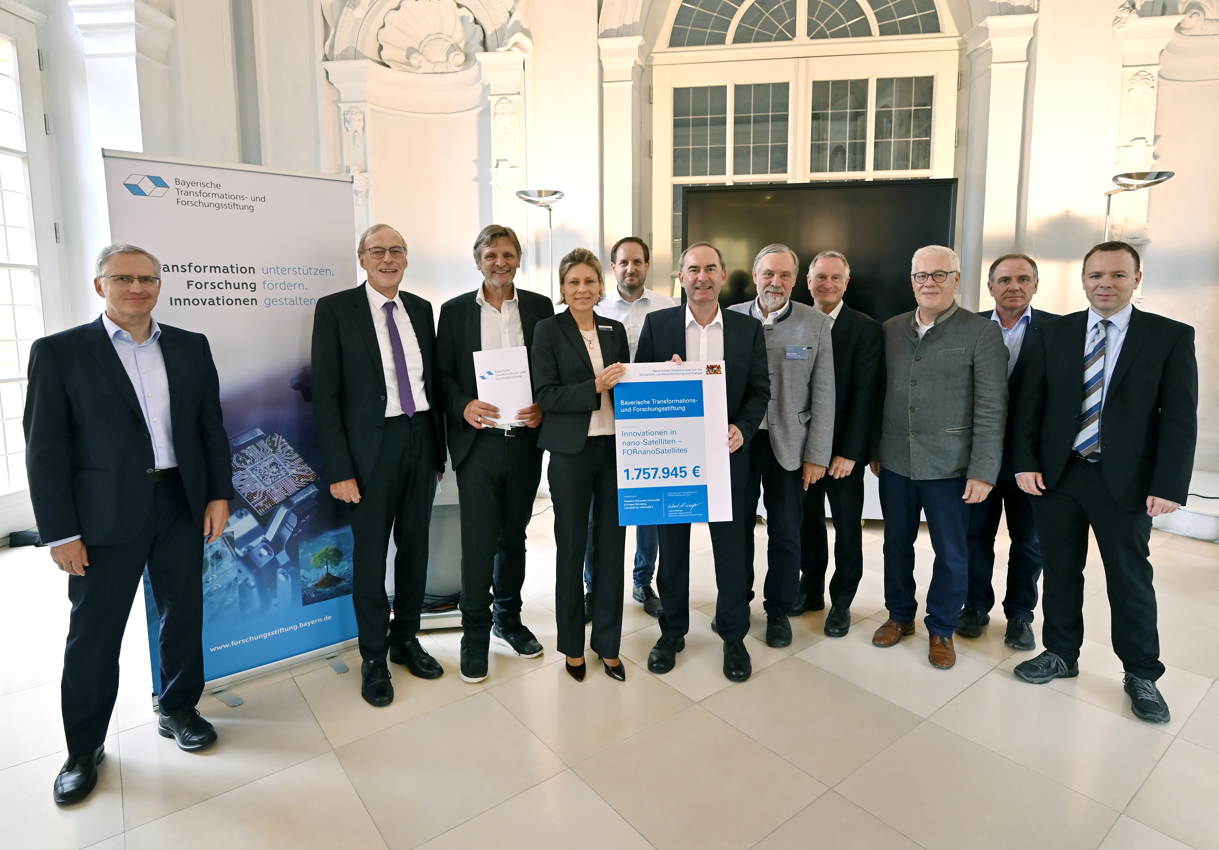Wirtschaftsminister Hubert Aiwanger hat in Erlangen den Förderbescheid für den Forschungsverbund FORnanoSatellites an Prof. Dr. Dietmar Fey (FAU, Verbundsprecher), Prof. Dr. Klaus Schilling (Zentrum für Telematik, stv. Verbundsprecher) und Yvonne Weitsch (Rhode & Schwarz GmbH & Co. KG, Industriesprecherin) übergeben. Ziel des mit rund 1,8 Mio. Euro durch die Bayerische Transformations- und Forschungsstiftung (BayTFS) geförderten Forschungsverbundes ist es, die Herstellung von Kleinstsatelliten effizienter und kostengünstiger zu gestalten sowie so zu digitalisieren, dass eine automatisierte Kleinserienproduktion in Bayern stattfinden kann. (Bild: FAU/Harald Sippel)